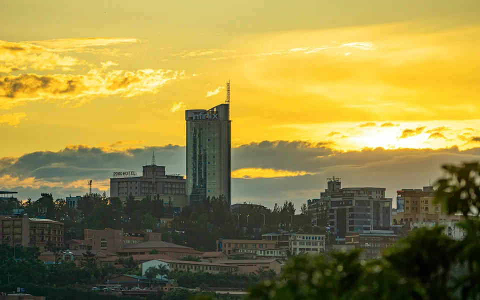 Kigali buildings and hillside beneath a golden evening sky